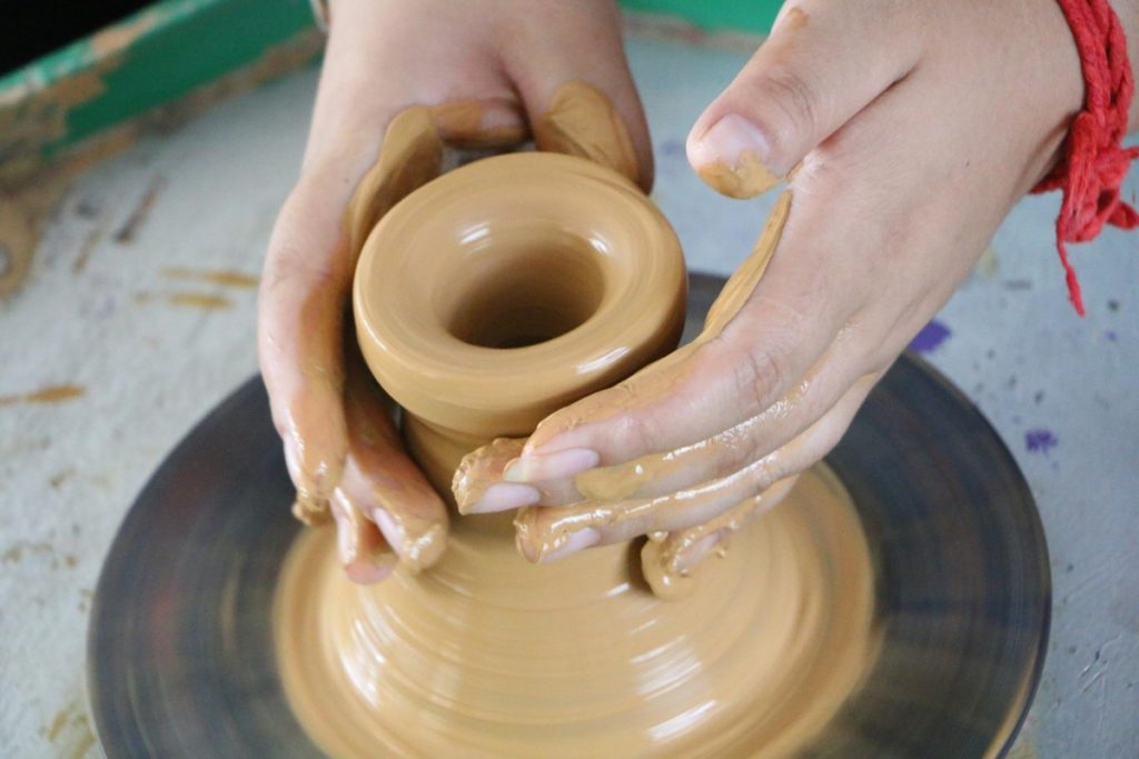 A woman making something out of clay.